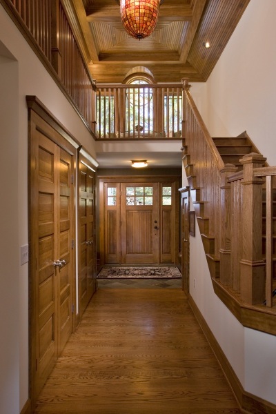 Entry door and two-story foyer in a Diamond Point, NY, Adirondack Craftsman restored by Teakwood Builders.