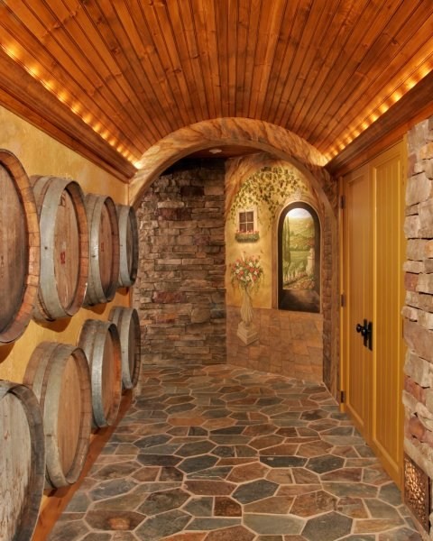 Vintage wine casks collected during the owners’ travels were reclaimed and recycled in this one-of-a-kind wine cellar wall treatment in Teakwood Builders' renovation of a Loudonville, NY, basement into a Tuscan wine cellar.
