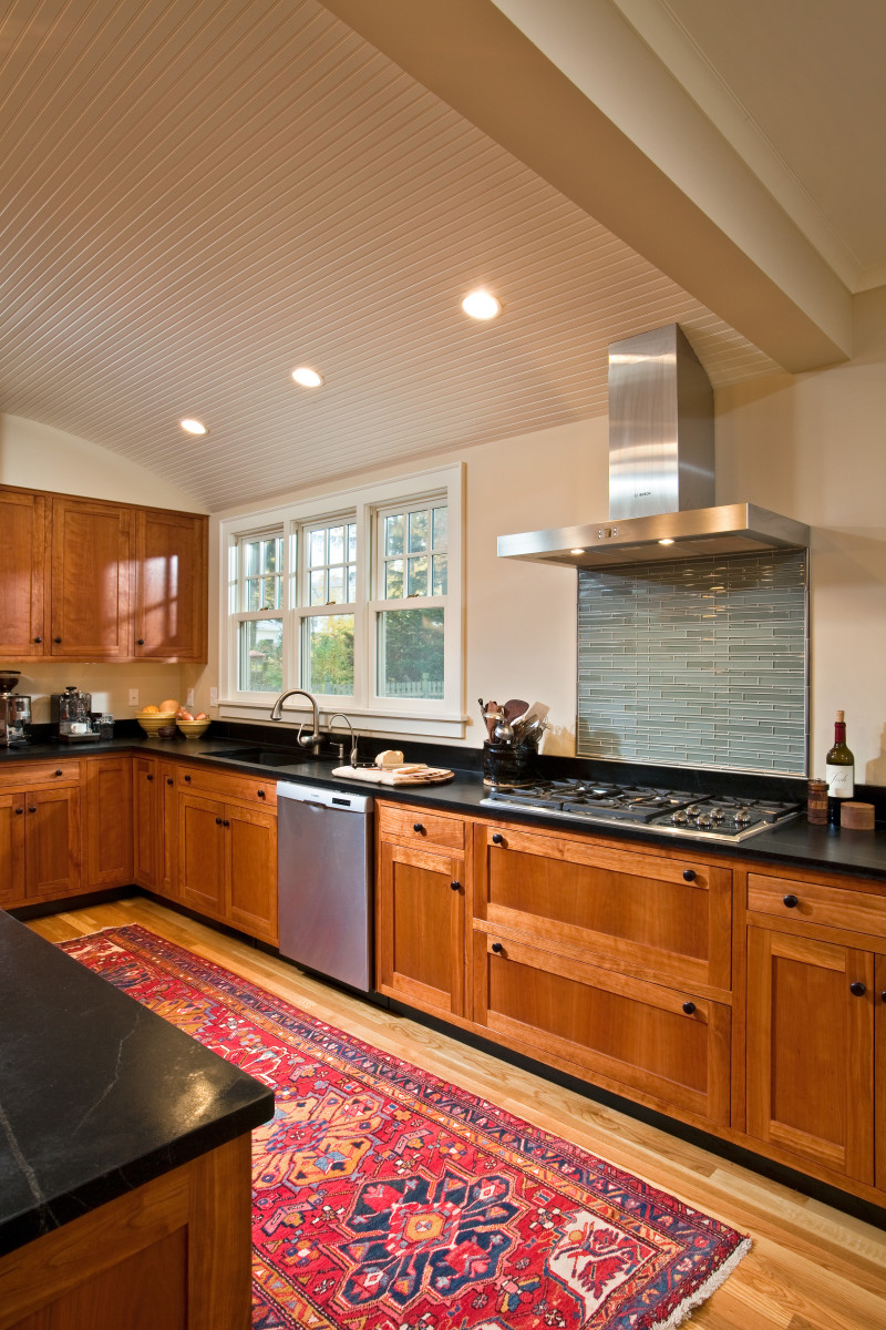 Teakwood used custom cherry cabinetry, soapstone counters and a barrel vaulted beadboard ceiling to set the stage for the modern stainless exhaust system in this 1927 Colonial Revival remodeled home. By Teakwood Builders, kitchen and bath remodeler, custom home builder and general contractor Saratoga Springs and Capital Region.