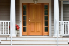 The new porch features mahogany decking, an edge and center bead fir ceiling, architectural columns, custom-milled rails and balustrade and a wooden entry door system.