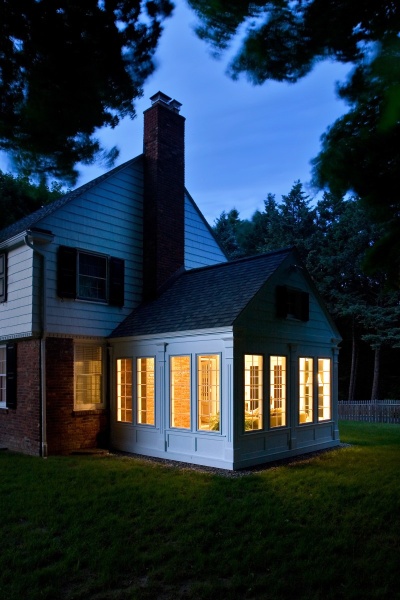 Bountiful casement windows on the porch addition to this Loudonville NY, home make for a light-filled, three-season retreat. The exterior gable was sided in cedar shingles to match the existing home and architectural panels beneath the windows and pilaster details befit the home’s 1940s roots.