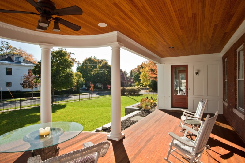 Rich, durable, natural materials were incorporated into this new sitting porch, including tongue-and-groove mahogany decking and Douglas fir for the beadboard ceiling. The Tuscan columns are of low-maintenance fiberglass, while exterior trim details are of primed cedar.