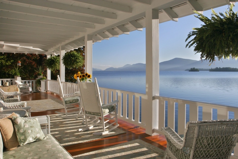 Lakefront porch on a Diamond Point NY Adirondack Craftsman enlarged and restored by Teakwood Builders.