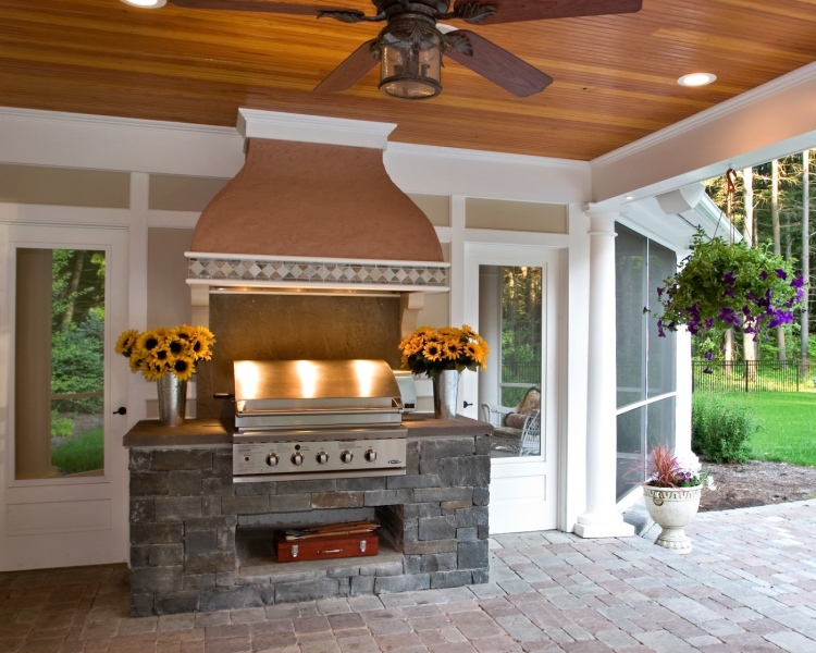 Teakwood Builders created poolside screened porch with a TV, kitchen with an outdoor cooktop crowned by a stucco hood and a bath with changing area. All are handsomely constructed with tailored millwork, dry-stacked bluestone and stucco highlights.