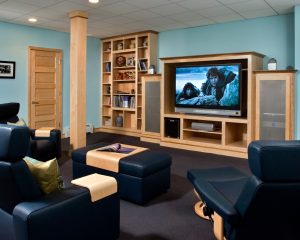 An entertainment center was crafted to house a large-screen TV and surround-sound components. The existing steel column was wrapped with maple to incorporate it as a more decorative element in the room. Special ceiling tiles ensure maximum enjoyment of this room’s acoustics.