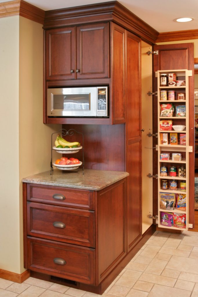 The custom millwork cabinetry created by Teakwood Builders for the microwave center has deep drawers for preparation and storage containers. The adjacent tall pantry cabinets make for easy grab-and-go food preparation.