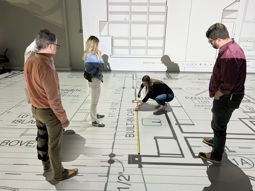 a designer demonstrates measurements to the clients