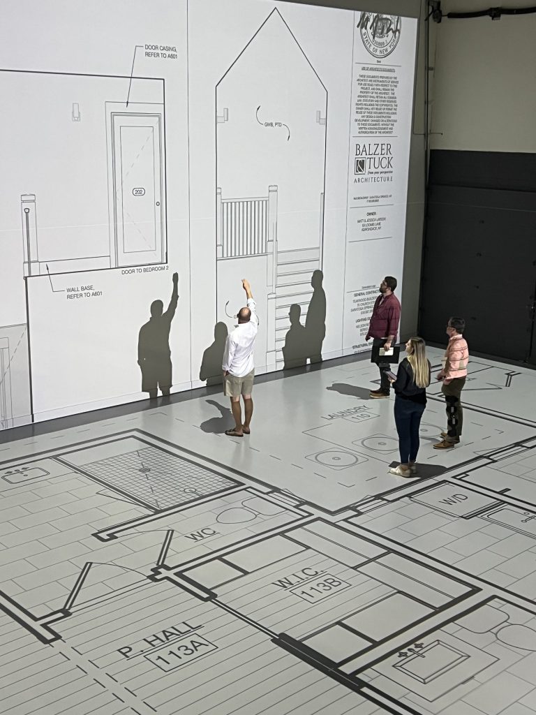 design team and client walking through home plans